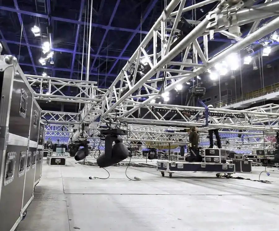 Montaje de truss en recinto de eventos — vista general con luces y equipo técnico
